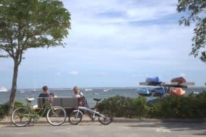 Couple sitting on waterfront bench with bikes
