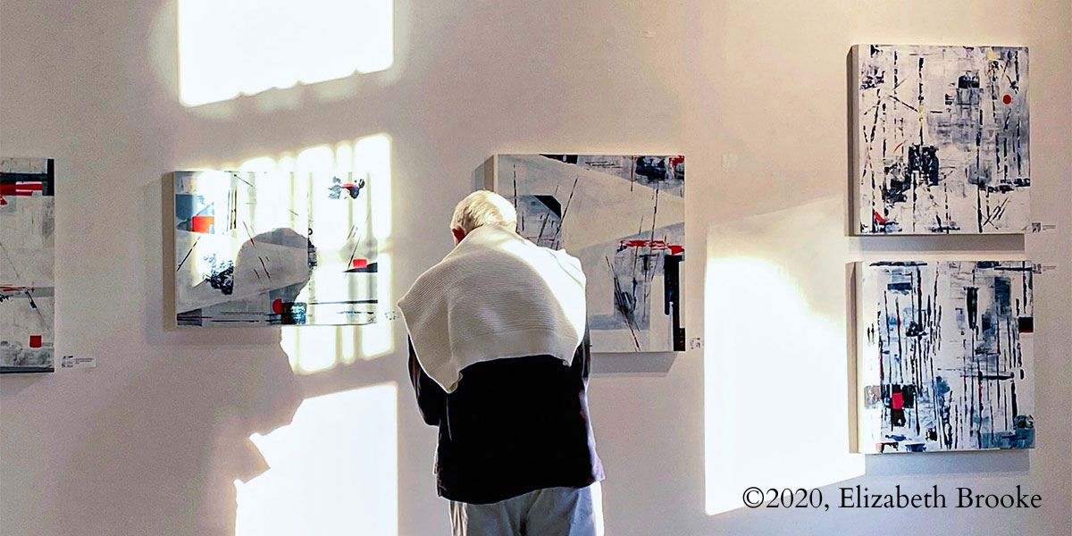 A man looking at some artworks at a Provincetown Museum