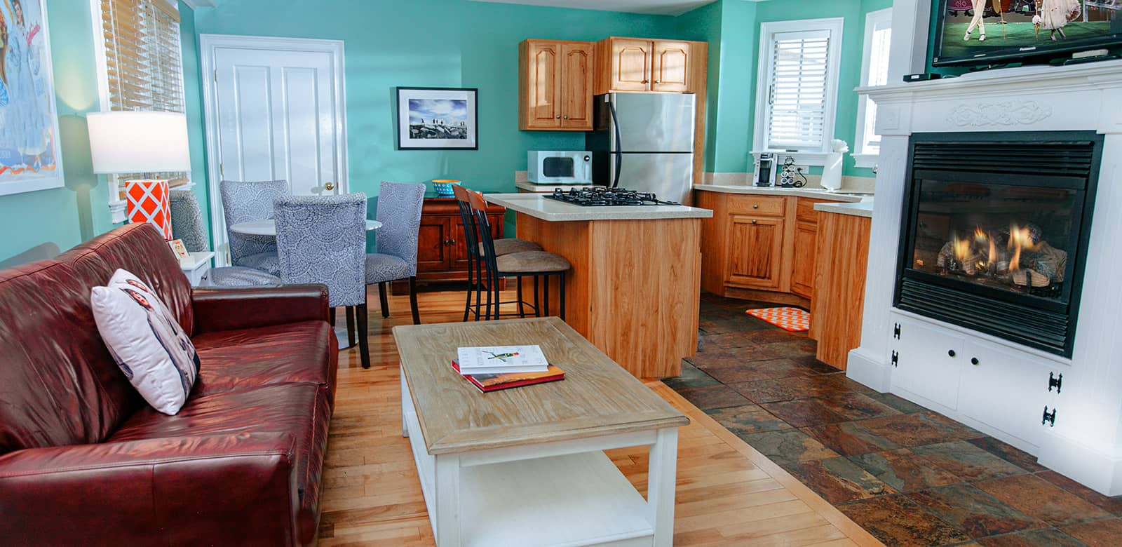 View of the fully-equipped kitchen, sitting area, and fireplace at our Bella lodging