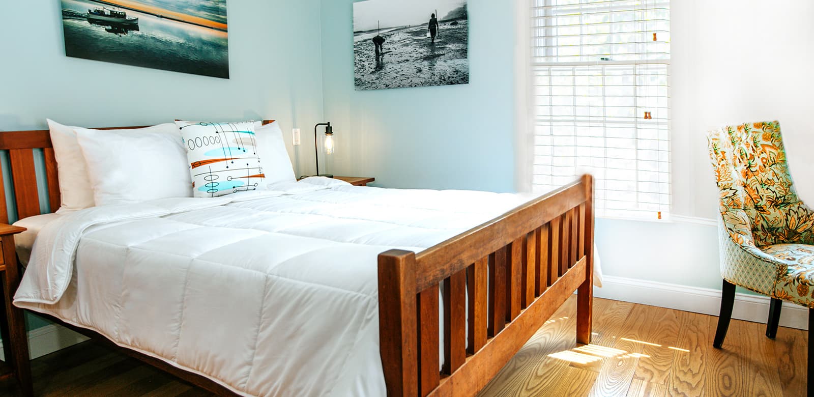 Queen size bed by a large window at Dorothea Dix