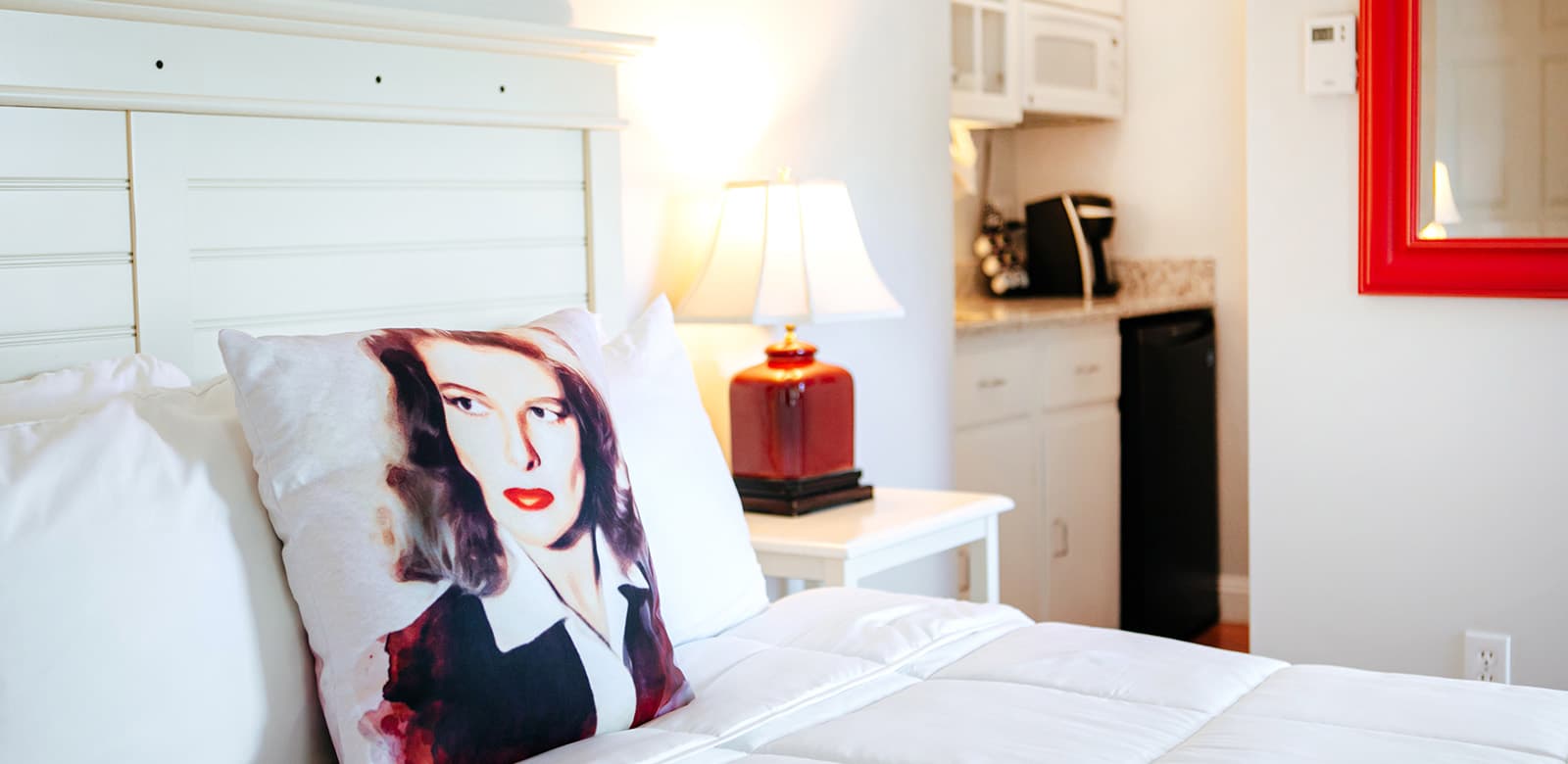 A pillow with Katharine Hepburn's face and a view into the snack kitchen alcove at our hotel room