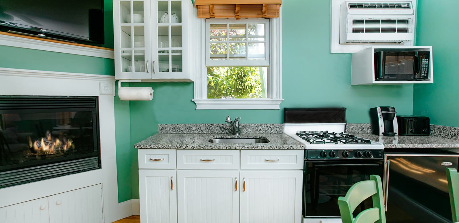 Fully-equipped kitchen with burners, oven, microwave, and a fireplace at Laurel
