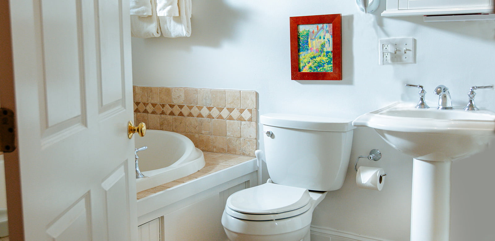 Bathroom entrance with view of toilet, whirlpool tub, and sink at Susan