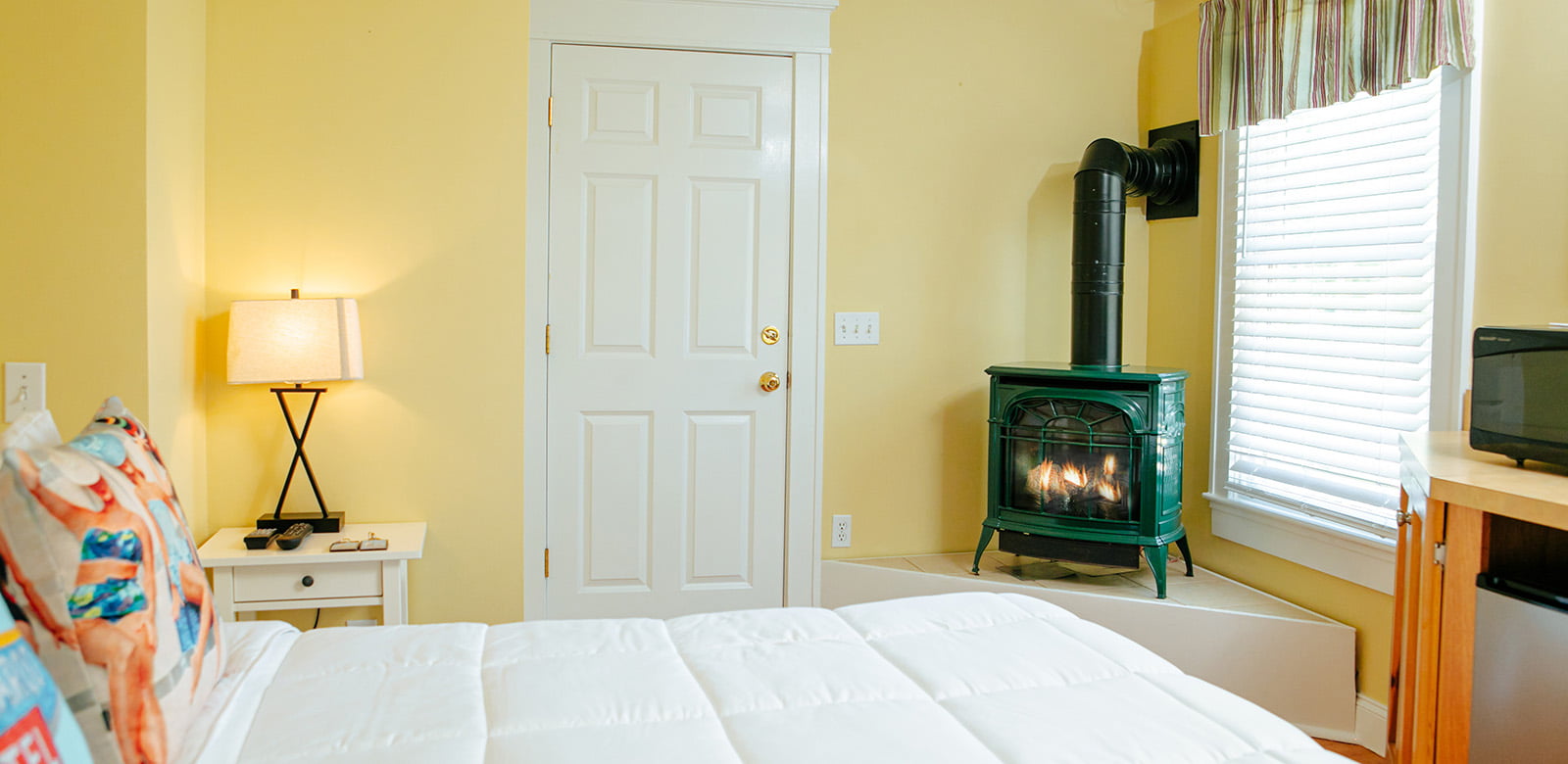 Queen size bed at Virginia Woolf with fireplace in the room of our hotel