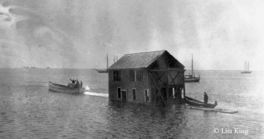 A house being floated across Provincetown Harbor from Long Point to the West End of Provincetown.