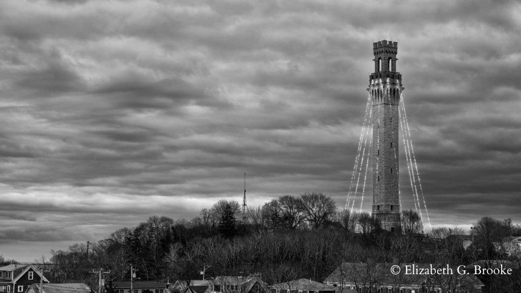A black and white photograph of the annual lighting of the Provincetown Monument
